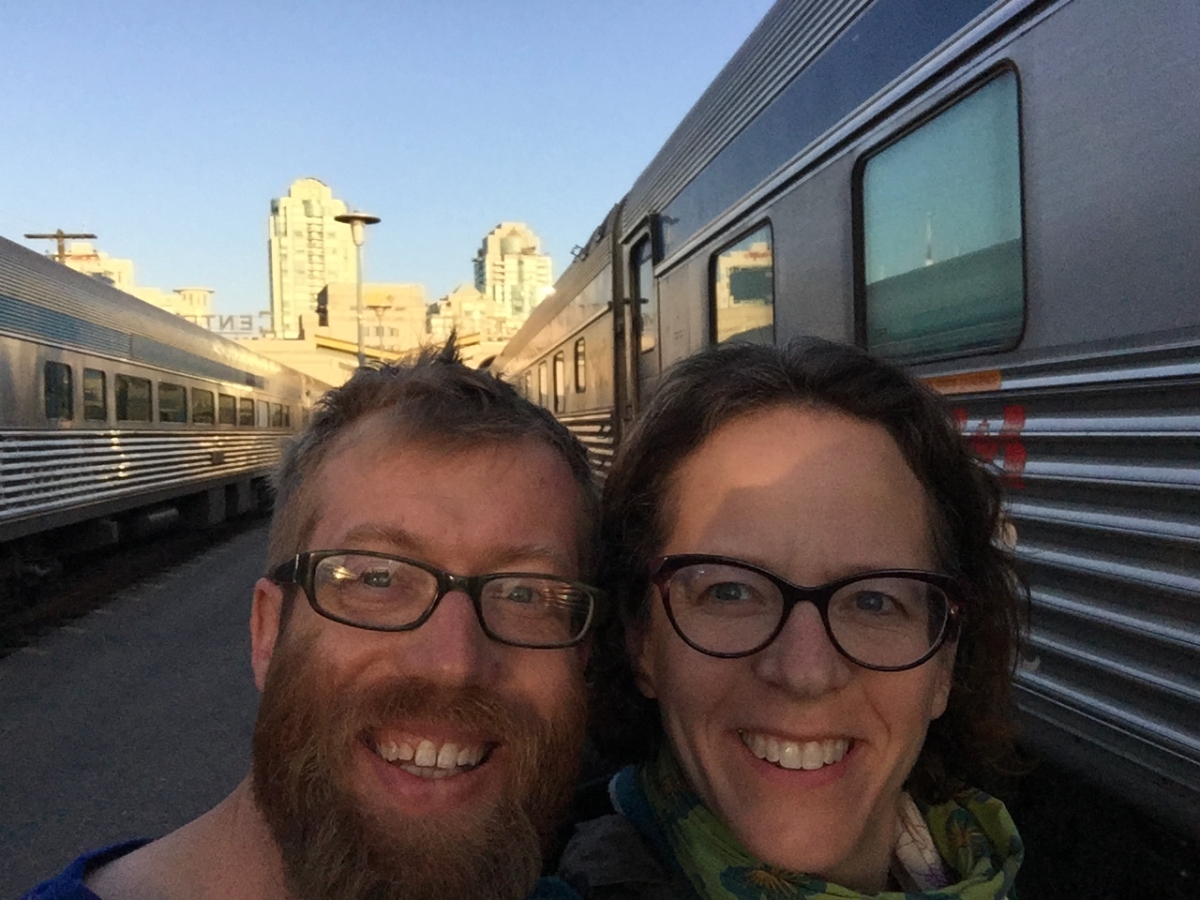 A man and a woman stand on a platform by trains in Vancouver, Canada.