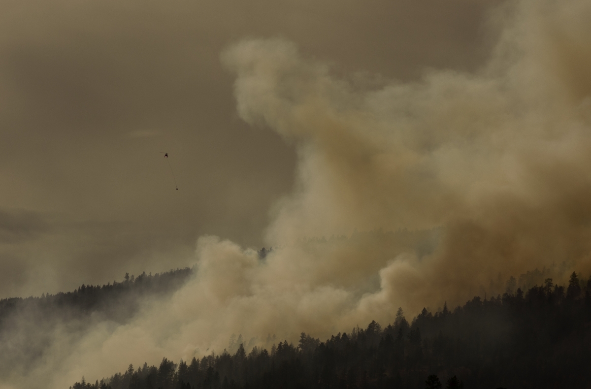 A helicopter bucketing a forest fire in British Columbia