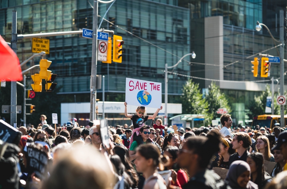 protest with a sign that reads save the planet