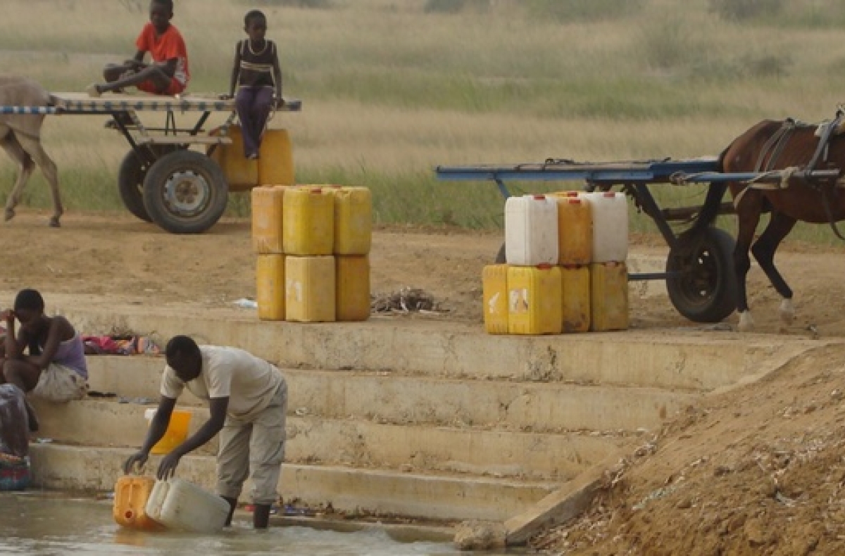 A man collects water from a river in Senegal.