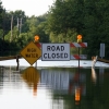 A flooded street with High Water and Road Closed caution signs