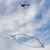 A giant electromagnet hanging from a helicopter.