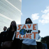 A climate protestor holds a sign that says "Save Our Planet"