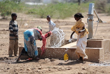 children playing by water pump