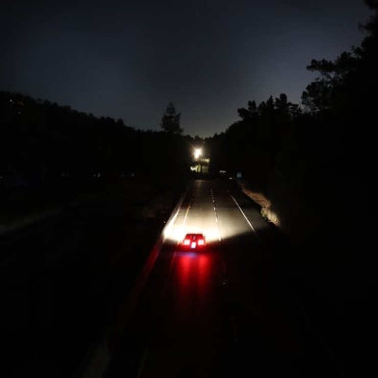 a car drives down a dark two-lane road at night