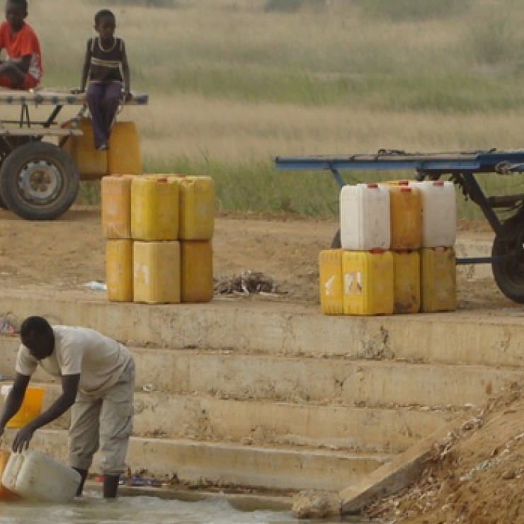 A man collects water from a river in Senegal.