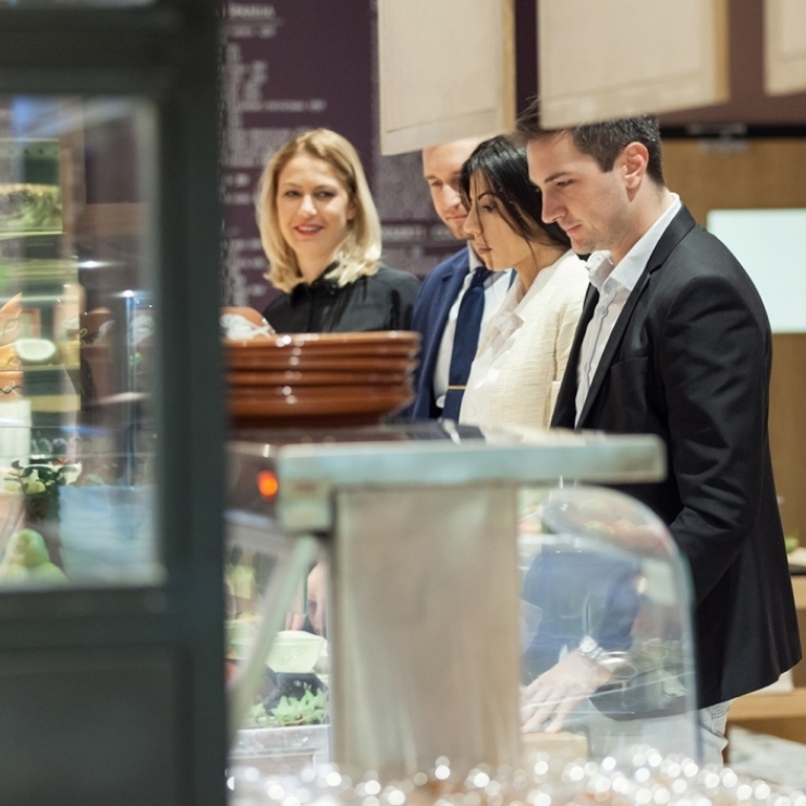 People lined up at a salad bar