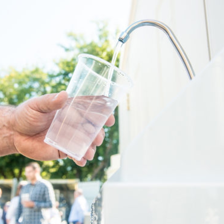 A cup fills up with water from a faucet