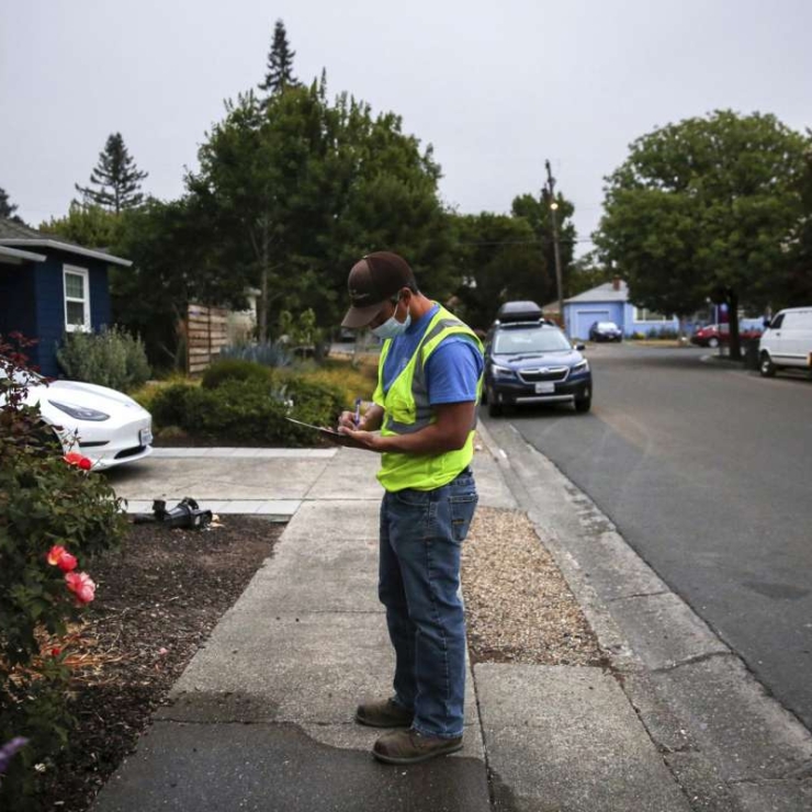 Utility system operator writes a notice to a resident not adhering to water restrictions in Santa Rosa